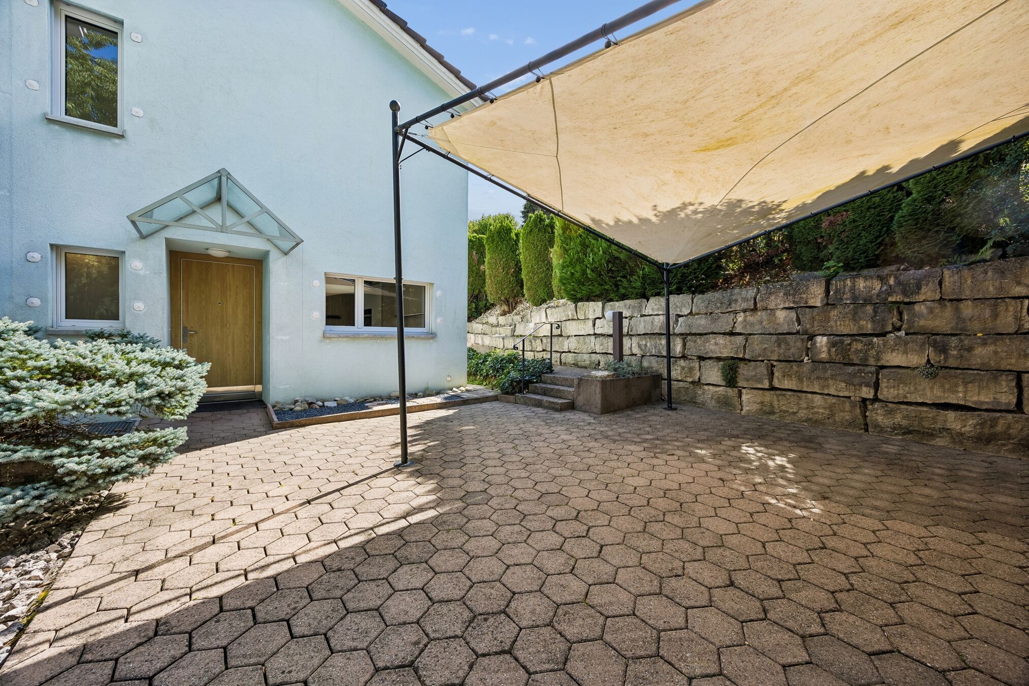 Hauseingang mit Sitzplatz und Sonnensegel